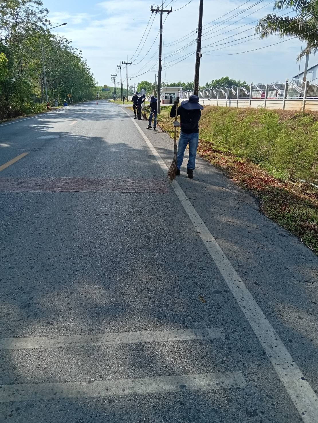 กวาดพื้นถนนและบริเวณข้างทางเข้าออกบริษัท